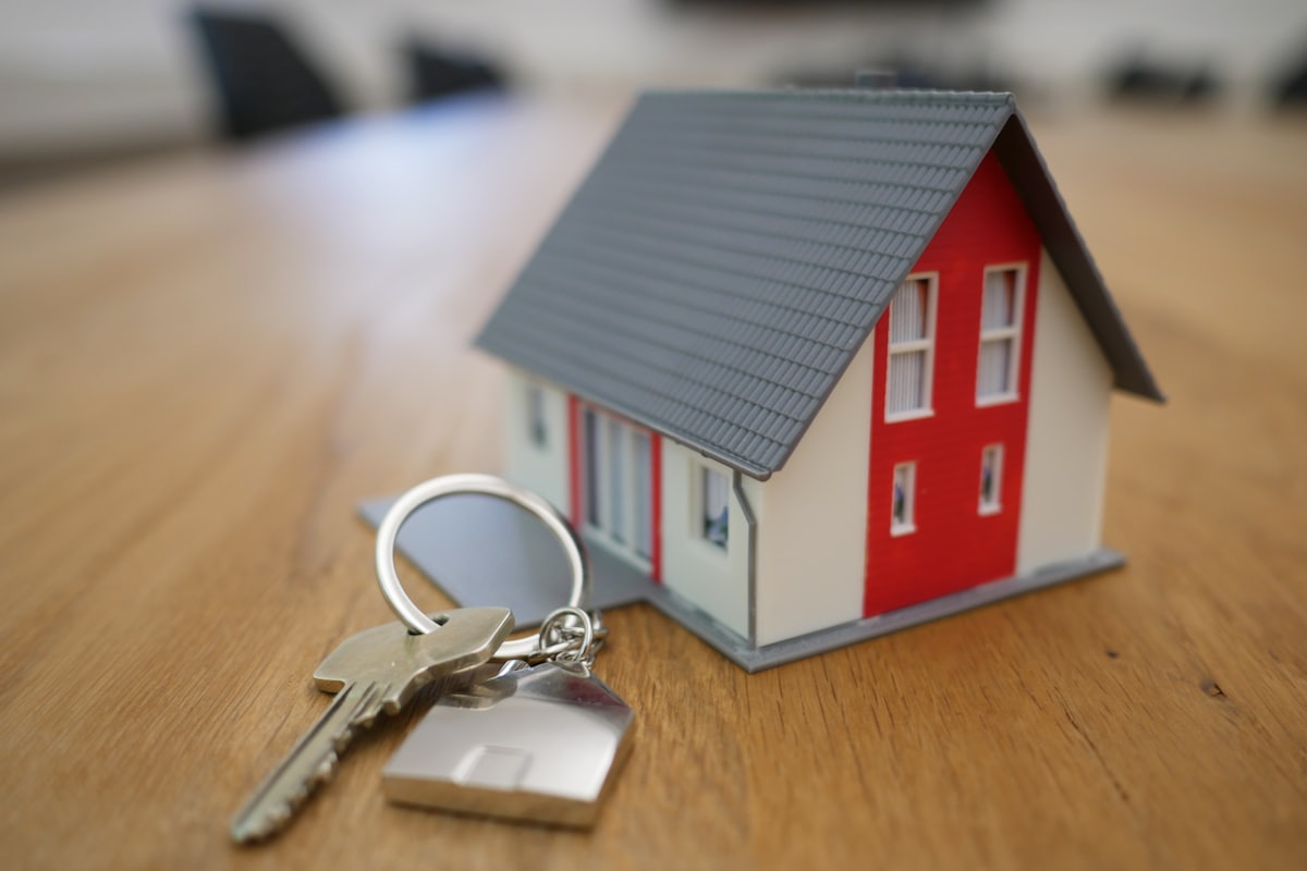 Remise des clés d’un logement, posées près d’une maquette de maison